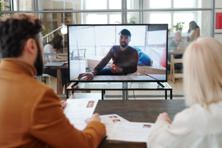 Two employers asking questions to man during online interview